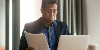 En mann går over noen papirer. Foto