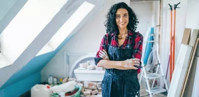 En dame står med armene foldet. Foto